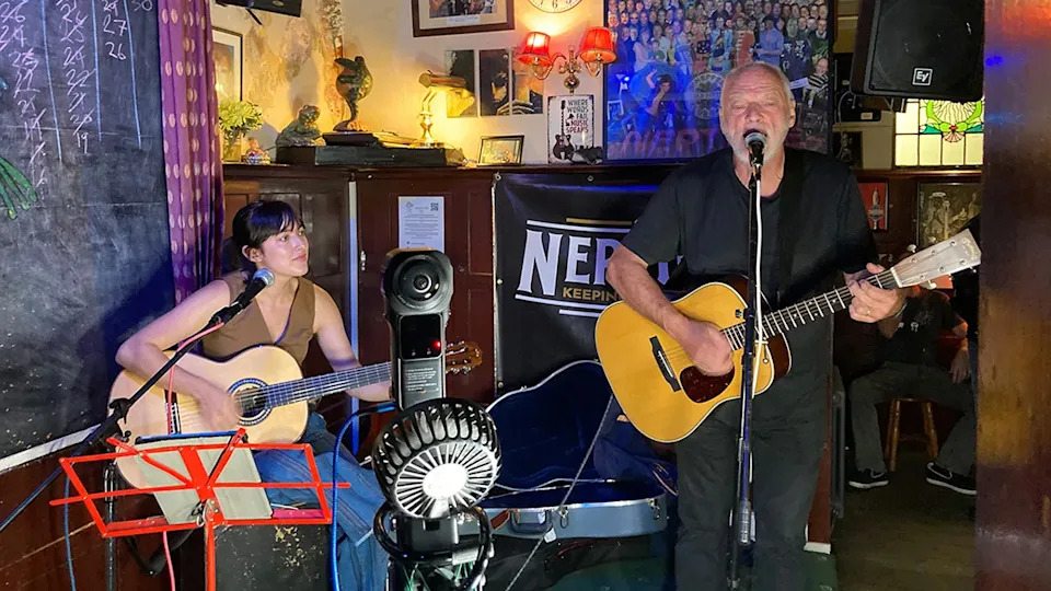 Acoustic guitarist performing on a small pub stage
